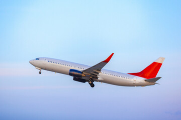 Passenger plane taking off from runway at airport on sunny day.