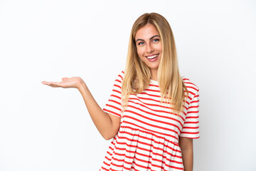 Blonde Uruguayan girl isolated on white background holding copyspace imaginary on the palm to insert an ad