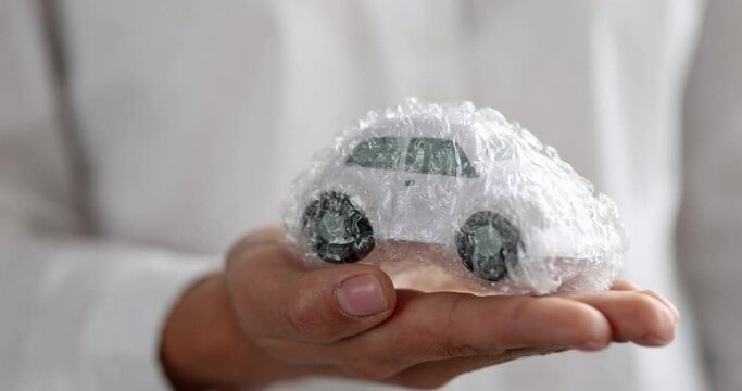 Woman hand holding toy car in protective plastic wrap 4k movie