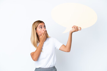 Blonde Uruguayan girl isolated on white background holding an empty speech bubble with surprised expression