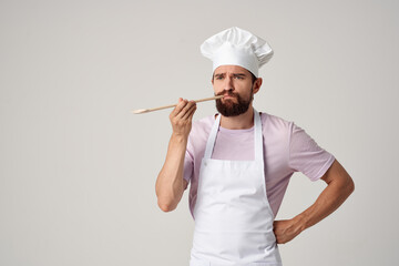 male professional chef in apron holding a spoon cooking food service