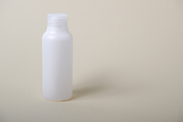 The concept of beauty salon and summer cosmetic White bottle for cosmetics on a beige background. Empty white plastic bottle