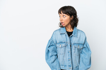 Young mixed race woman isolated on white background doing surprise gesture while looking to the side