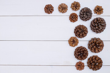 Christmas background - pine cones on white boards.