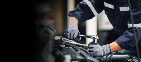 Fototapeta na wymiar Mechanic works on the engine of the car in the garage. Repair service. Concept of car inspection service and car repair service.
