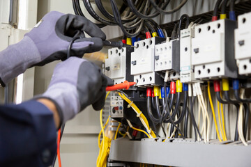 Electrician engineer tests electrical installations and wires on relay protection system....