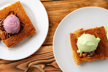 Turkish dessert kunefe served with ice cream on wooden background