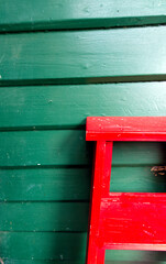 Red  ladder on a green wall