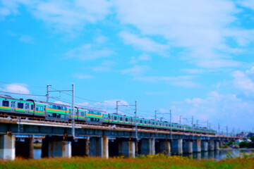 青空を背景に河を渡る列車