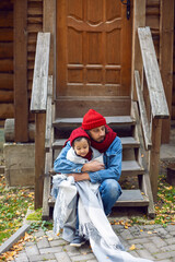 father and son in red hats and knitted scarves are sitting