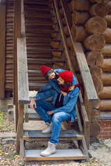 Fototapeta premium father and son in red hats and knitted scarves are sitting