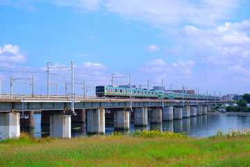 Fototapeta na wymiar 青空を背景に河を渡る列車