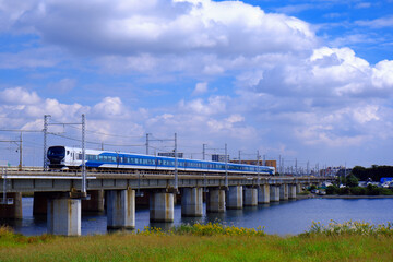 青空を背景に河を渡る列車