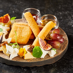 assortment of cheese and fruits with honey and red sauce