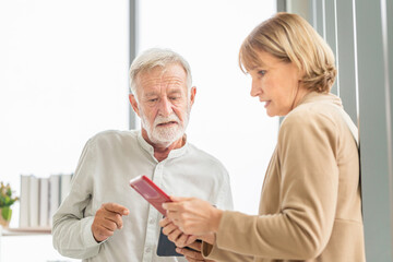 Portrait of happy senior couple in living room, Elderly woman and a man using tablet smartphone at home, Happy family concept