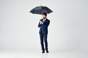 man in a suit with an umbrella in his hands weather protection