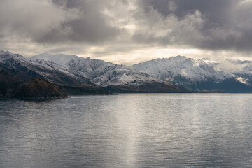 Fototapeta na wymiar Southerns Alps by Lake Hawea on a cloudy winter day. Otago, New Zealand