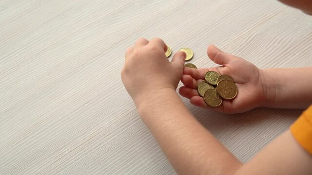 Little boy collects euro cents coins in hand, child savings, kids learn to count,  counting money.
