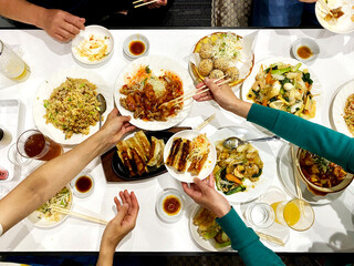 食卓で中華料理を取り分ける女性の手_俯瞰