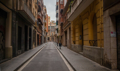 Fototapeta na wymiar narrow street in the town of Barcelone, au fond la rue la casa Vicens 