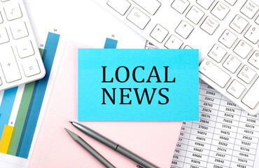 LOCAL NEWS text on blue sticker on chart with calculator and keyboard,Business concept