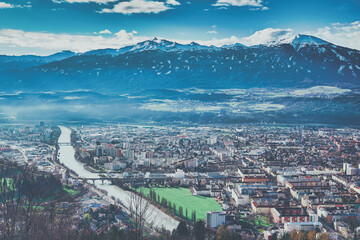 a view of the city of Innsbruck, next to the river Inn, with a large mountain, the Patscherkofel, in the background