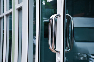 Closeup view of metal handle of glassdoor of the shop, soft and selective focus.