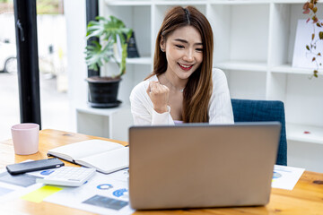 Beautiful young Asian woman gesturing in front of a laptop, concept image of Asian business woman working smart, modern female executive, startup business woman, business leader woman.