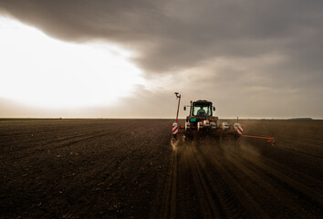 Obraz premium Farmer with tractor seeding