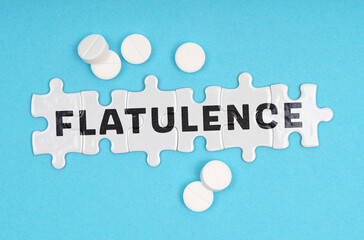 On a blue background pills and puzzles with the inscription - FLATULENCE
