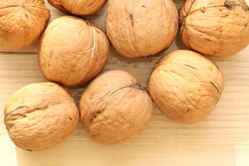 Walnut on a light wood background. Walnut is the fruit of a tree that can reach a height of 25 meters and live up to 400 years. 