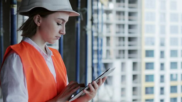 Engineer or Architect working at Construction Site. A woman with a tablet at a construction site. Construction concept.