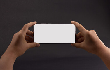 2 hand holding smartphone in horizontal isolated on black background. Customers can put ads, website pages or information that they want to be displayed on the phone screen.