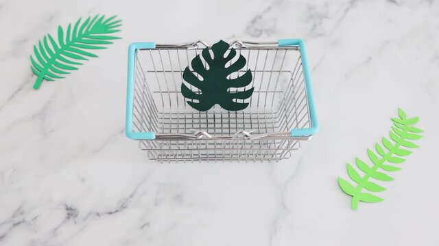 environmental awareness and consumer behaviour conceptual image, metaphor of shopping bag with tropical green paper leaves in it