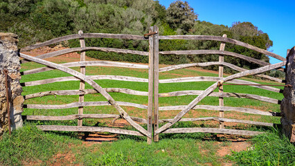 typical Minorcan gate made in wood with landscape behind. Menorca, Balearic Islands, Spain.