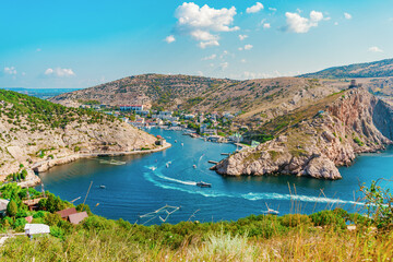 A picturesque panorama of the Balaclava view with yachts and a colorful bay in summer. Postcard view of the tourist Crimea.