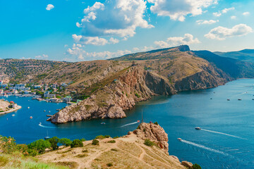 Obraz premium A picturesque panorama of the Balaclava view with yachts and a colorful bay in summer. Postcard view of the tourist Crimea.