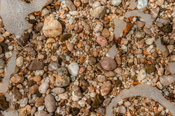 Small pebbles under the sea water on the beach