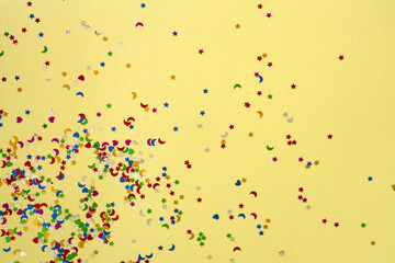 Colorful sparkles on the light green trendy background. Festive backdrop with small stars and moons. Holiday's wallpaper. High-quality photo