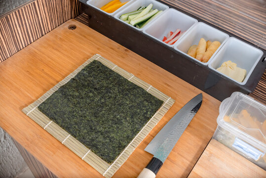 The ingredients for preparing California Maki and other sushi - Nori seaweed, mango, cucunber, crab sticks, battered shrimp and cheese. At a Japanese food stall.