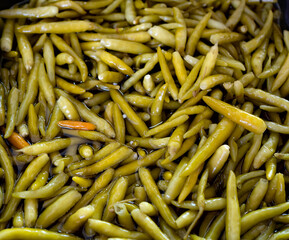 Real food background: green pickled peppers and beans in brine. Close up, top veiw.