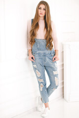 Young beautiful woman in denim overalls