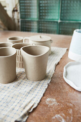 Working table of a ceramist. Clay workshop. The process of creating pottery. The master ceramist works in her studio