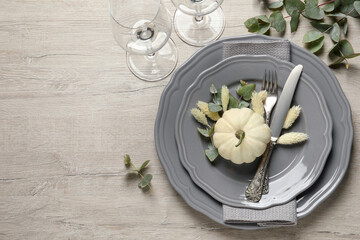 Festive table setting with autumn decor on wooden background, flat lay. Space for text