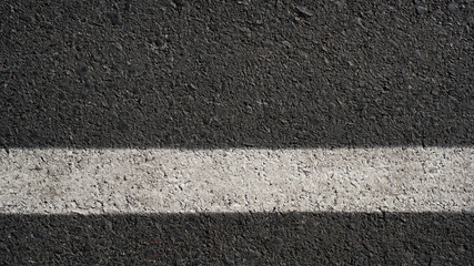 Fototapeta premium Surface grunge rough of asphalt, Seamless tarmac dark grey with white line on the road and small rock, Texture Background, Top view