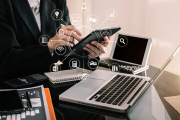 Business man using digital tablet analyzes business data, busy working on laptop computer with smart phone and business report on office desk, business strategy analysis concept.