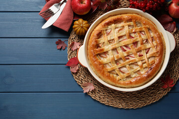 Delicious homemade apple pie and autumn decor on blue wooden table, flat lay. Space for text