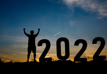 Happy new year Silhouette sunset background.A man standing next to 2022.new year,success,2022, Photo Silhouette and new year  concept idea.