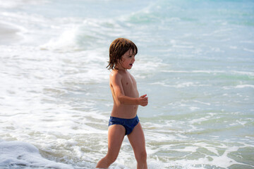 Fototapeta na wymiar Boy playing on beach. Summer vacation. Summertime kids weekend. Child at ocean.