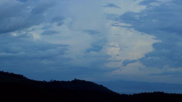 Magical blue clouds swirl over the mountain at sunset. Timelapse, relaxation weather dramatic beauty atmosphere background